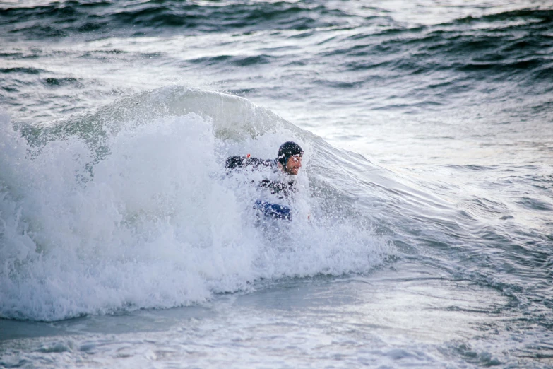 the person in the wet suit is falling off their surfboard