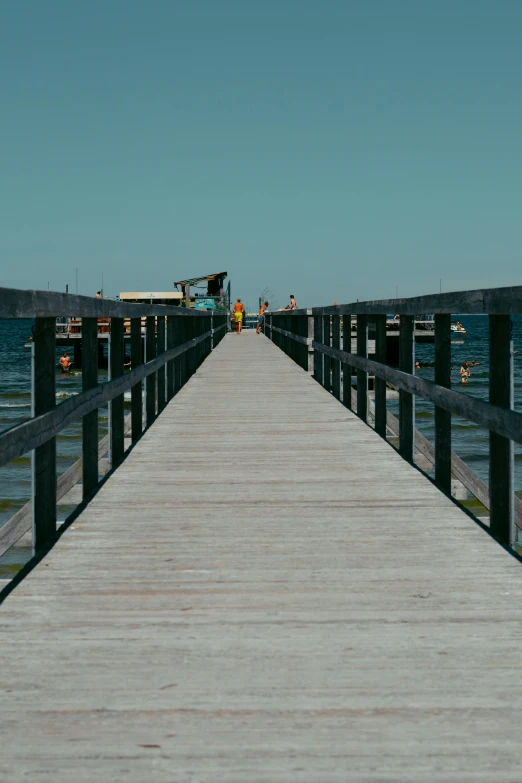 a long pier extends to a boat on the water