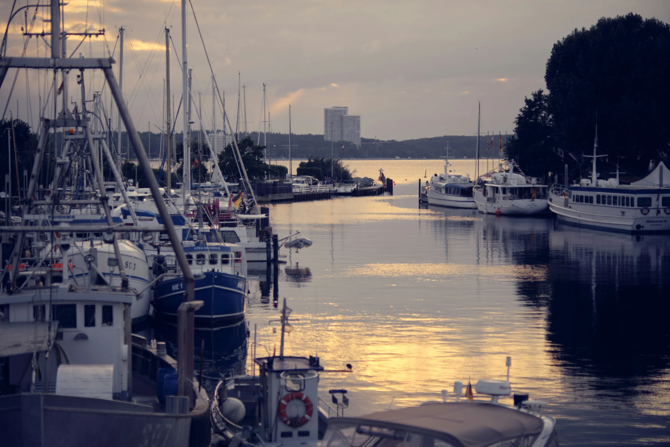 several boats sit in the marina as the sun sets