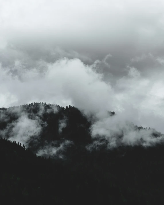 a black and white po of a mountain peak in clouds