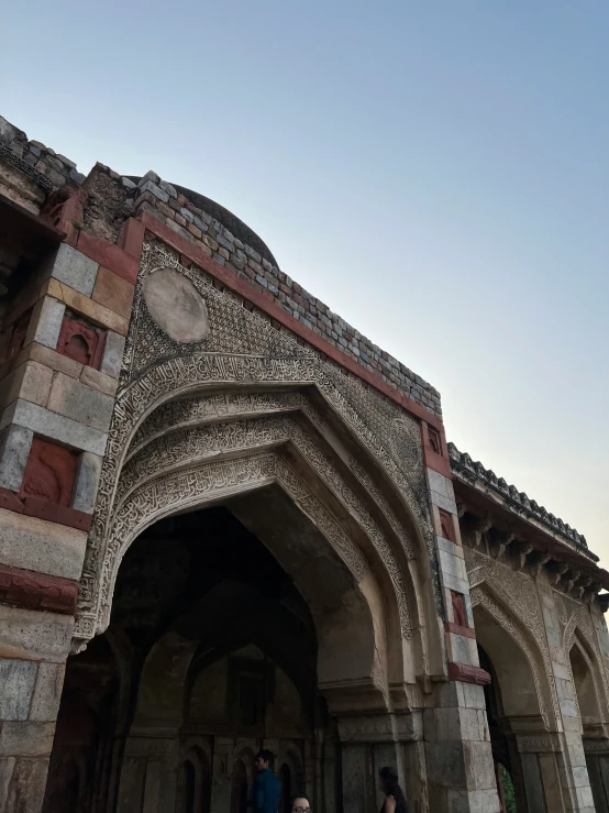 two people walking in the front of an intricately designed building