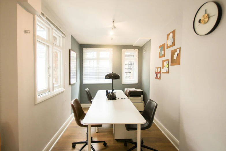 an office area with table and chairs in the corner