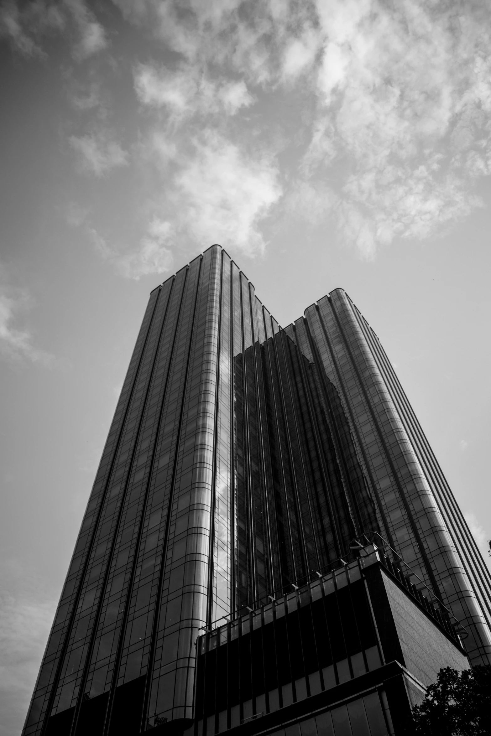 two skyscrs against a cloudy sky in the city