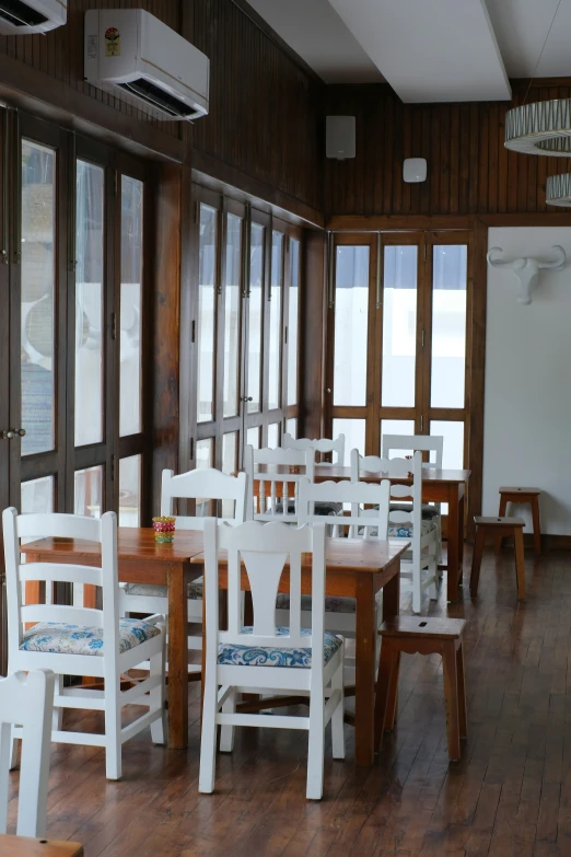 the white chairs are empty in the dining room