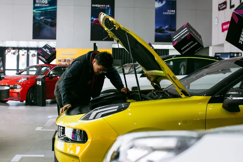 a man looking at a car with its hood open