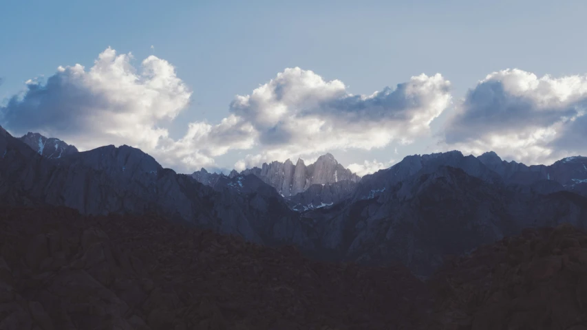 the mountains are very rocky against the cloudy sky