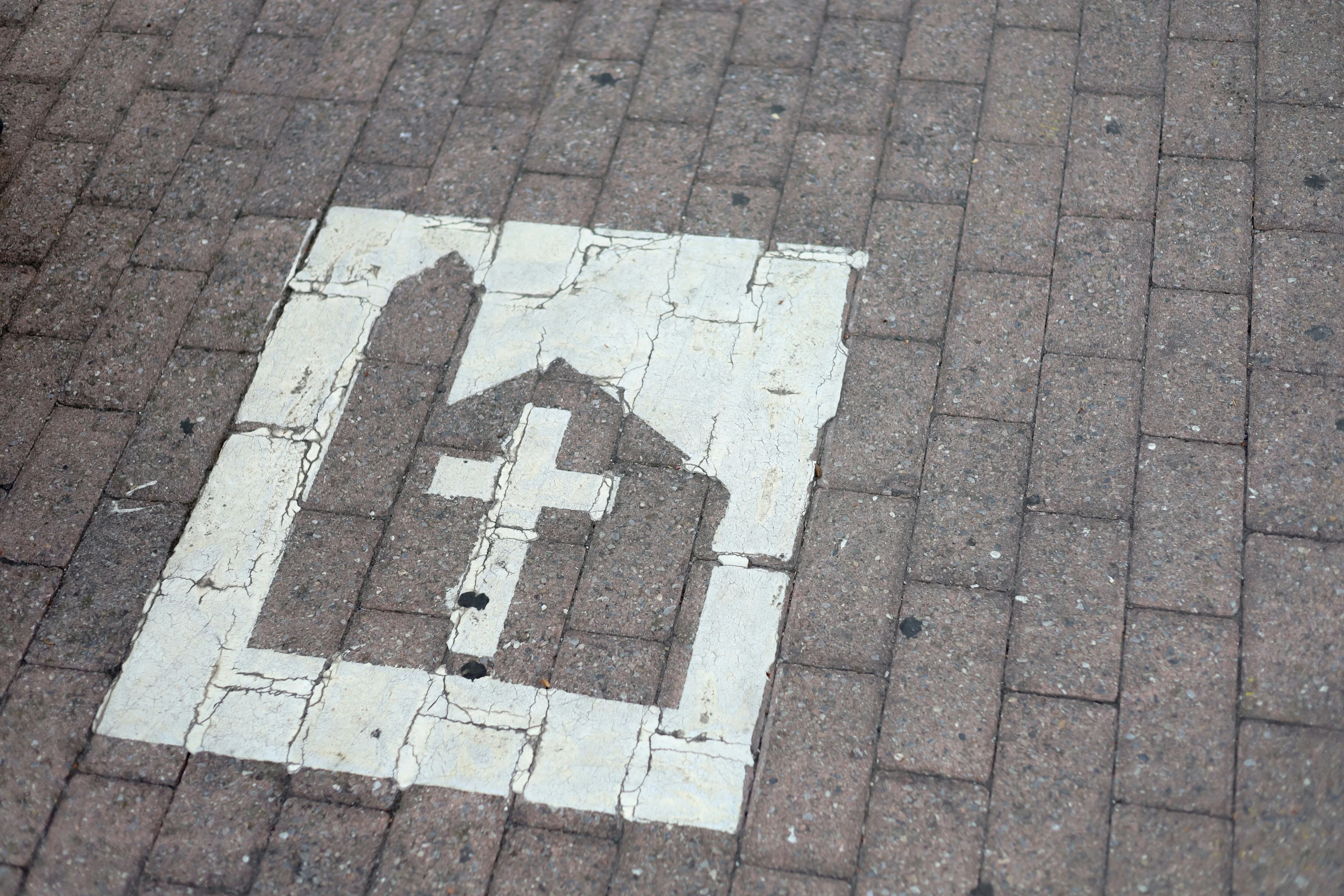 an artisticly painted arrow with houses on a brick sidewalk