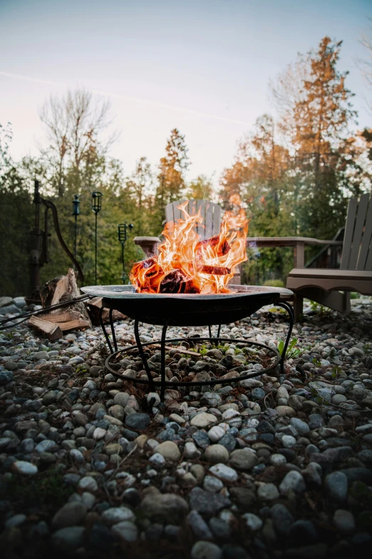 a fire pit on rocks near a park bench