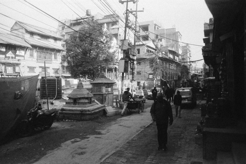 people and vehicles in black and white near an alley way