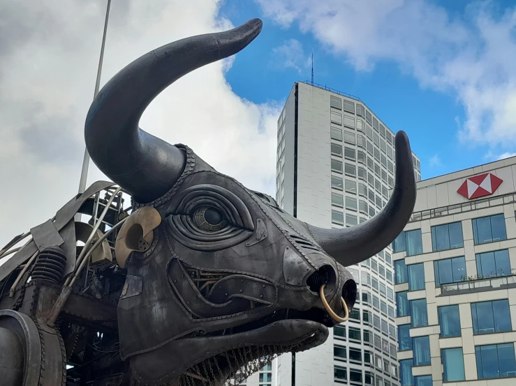 a sculpture of a bull with very long horns in front of a building