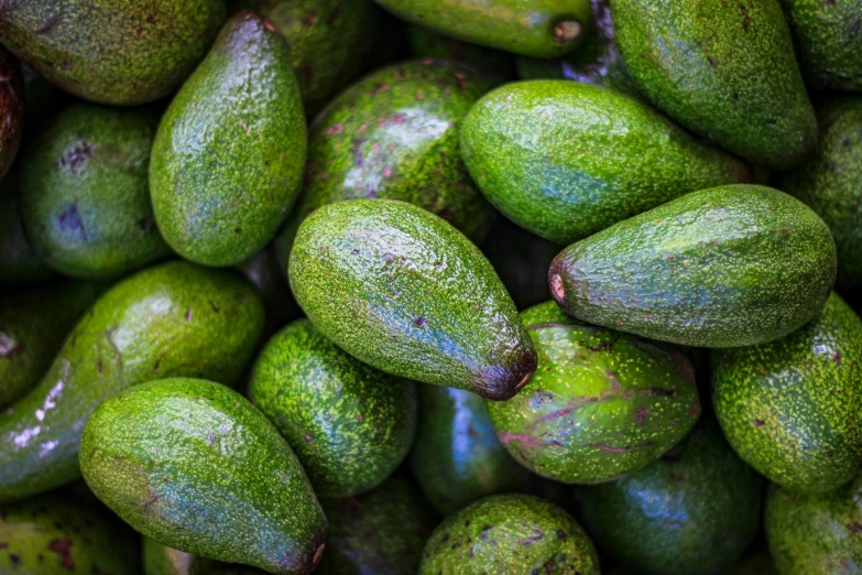 a pile of green fruit sitting on top of a table