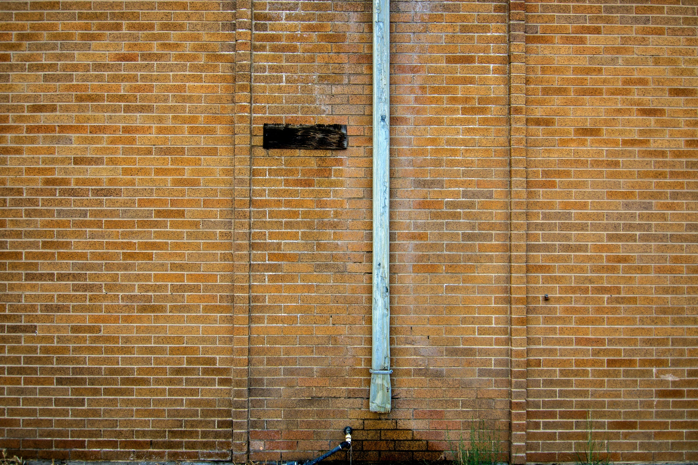 a fire hydrant next to a brick wall with an electrical pole