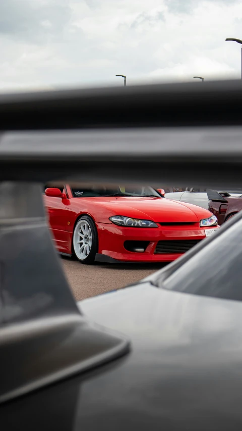 two red cars are parked in a parking lot