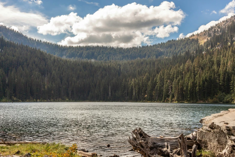 a lone boat is moored on the edge of a mountain lake