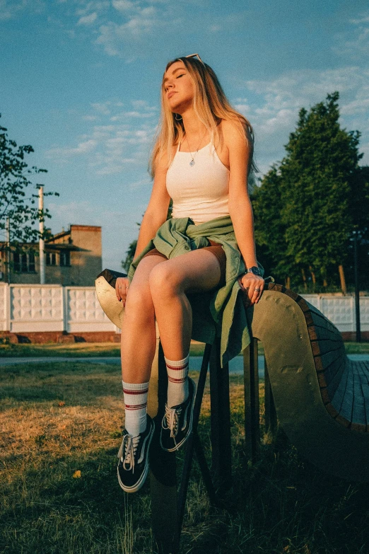 a young woman in white shirt sitting on chair outside