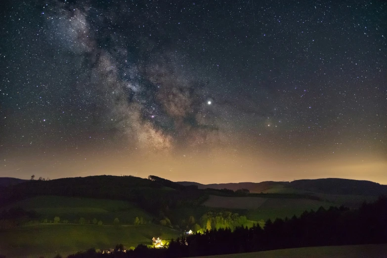 the stars shining brightly above a mountain side