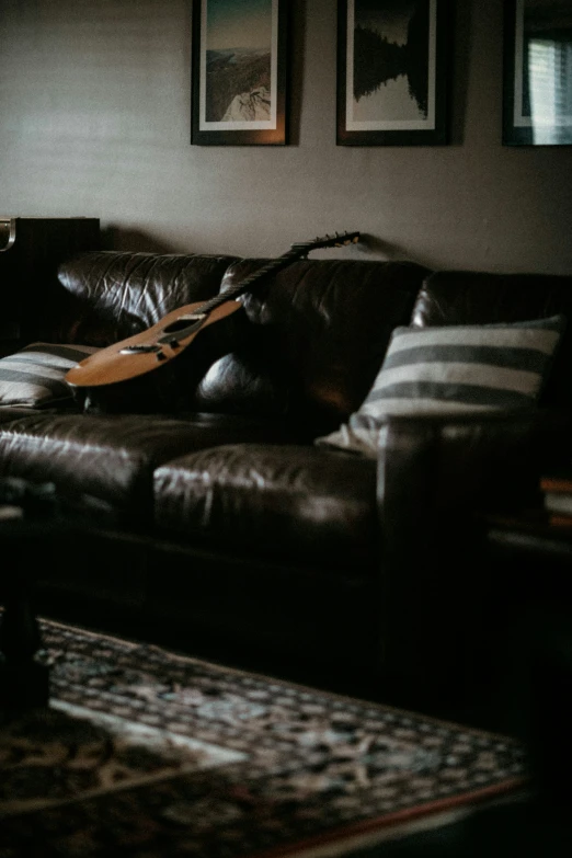 a couch in a room with a guitar laying on it