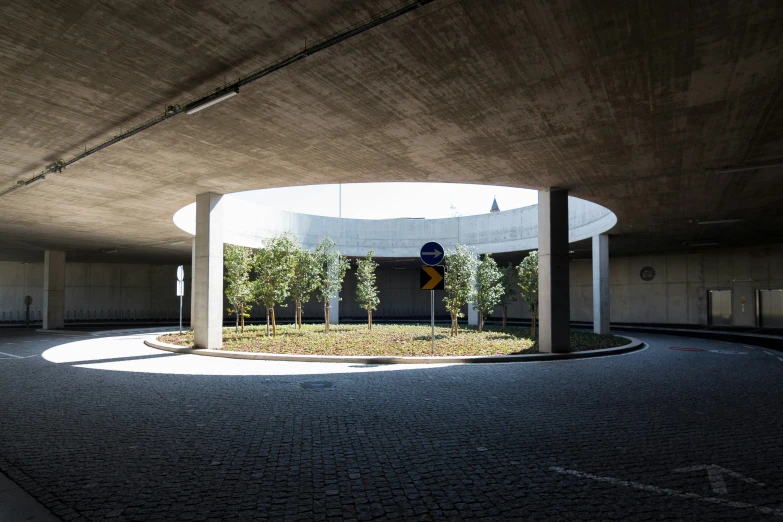 a empty parking lot under an overpass, with round plants