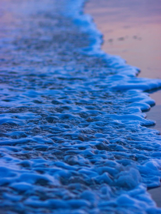 blue waves are hitting on the beach sand