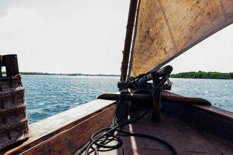 a small sail boat on a river with water around it