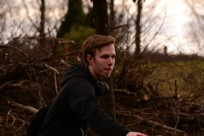 a man holding a white frisbee in the woods