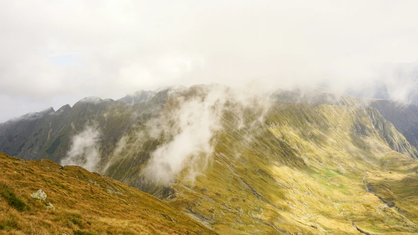 a group of mountains covered in fog and clouds