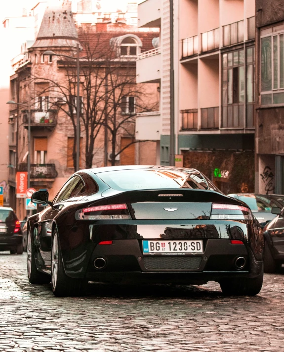 the back end of a black car on a street