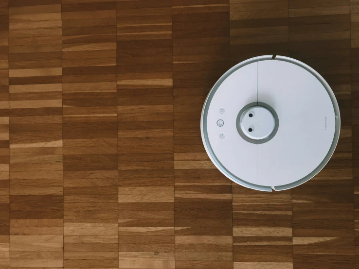 this image depicts a robot vacuum that is on the floor