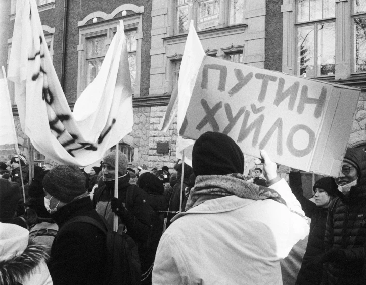 people hold up white flags and signs as they protest against president nixon