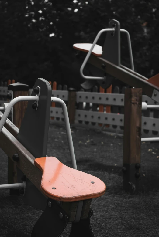 the orange chair is near the bench and the white bars