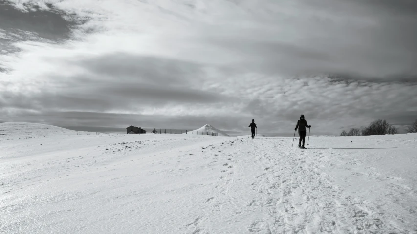 two men walking up a snow covered hill