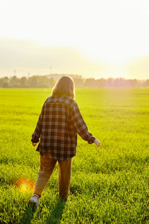 the girl stands in the grass and looks away from the camera