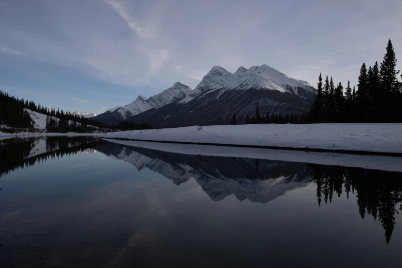 a clear lake in the mountains with a reflection on the water