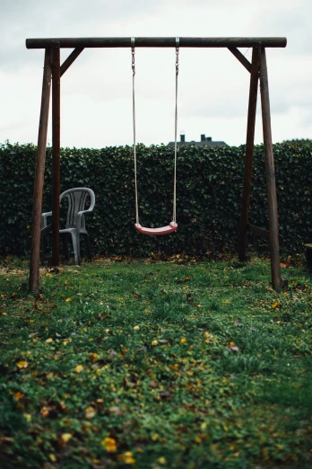 a chair sitting on a swing in a backyard