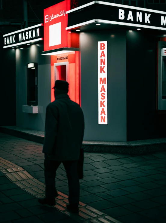 a man standing outside a bank in front of a building