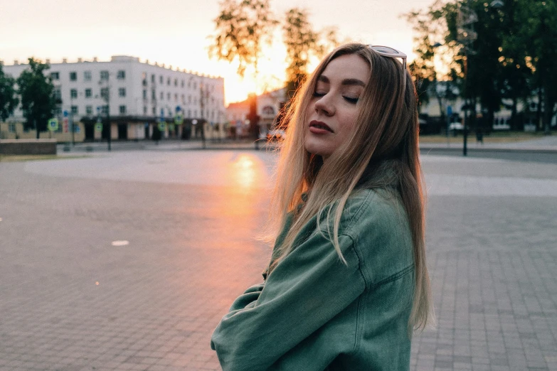 the girl with a long hair is standing on the sidewalk