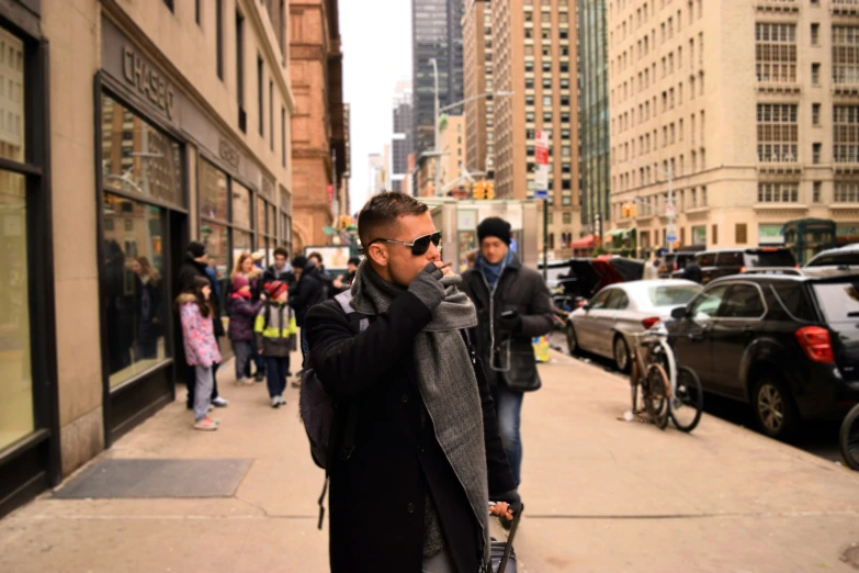 a man in black jacket standing on sidewalk with umbrella