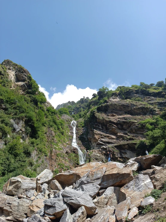 many rocks with trees and a body of water on it