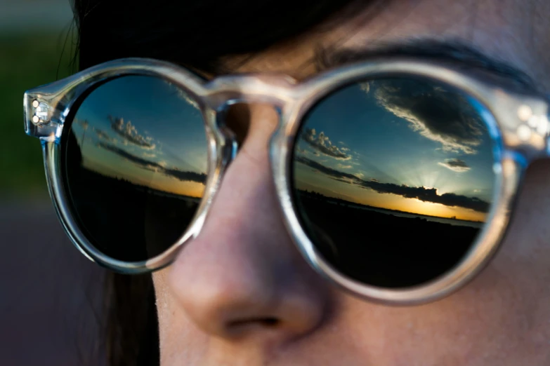 a girl with her reflection in some sunglasses