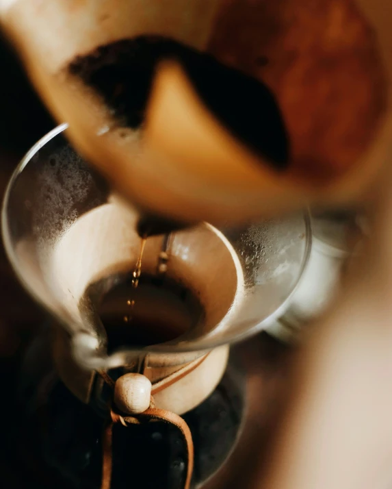 some liquid is being poured into the top of a coffee pot