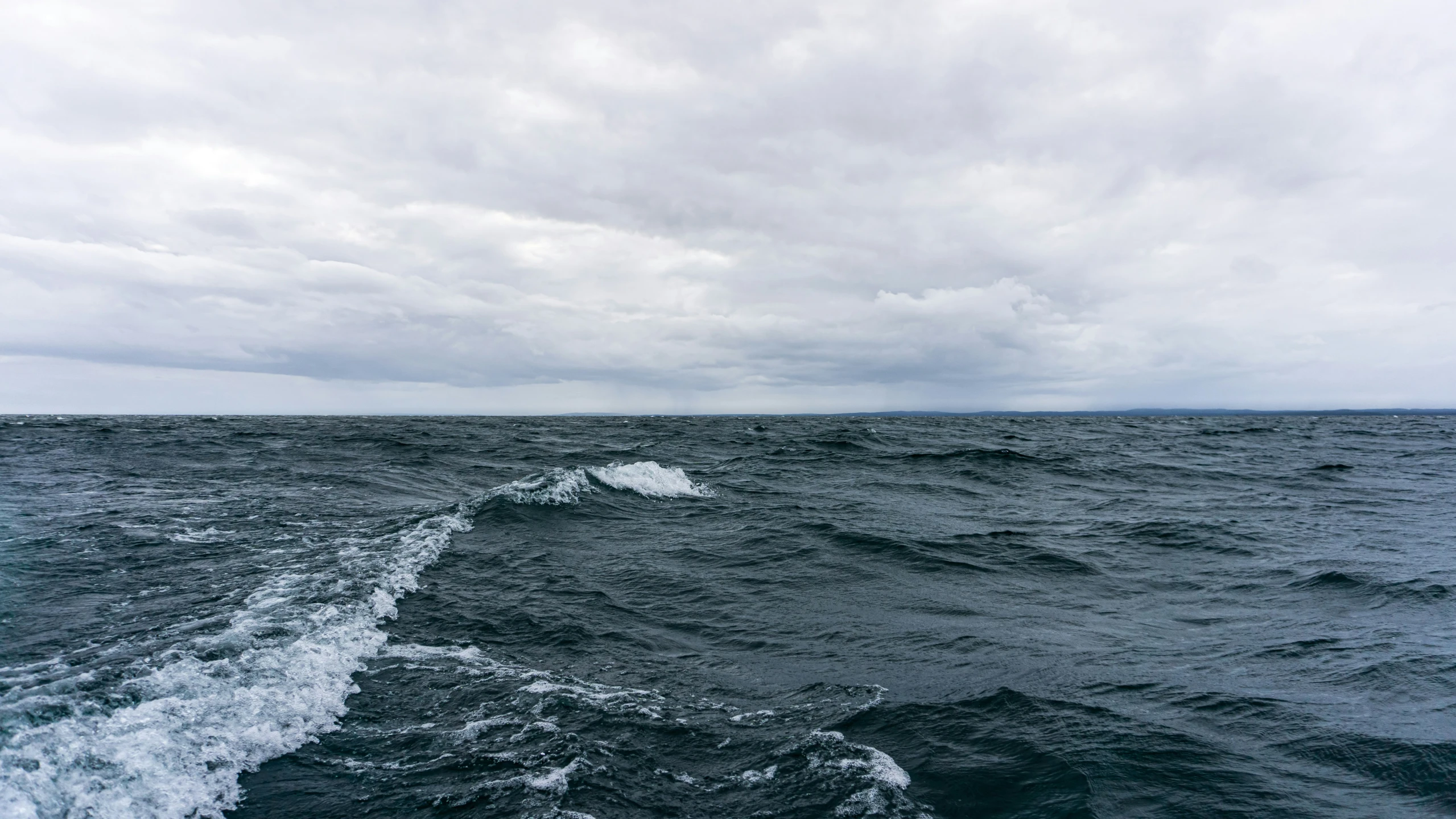 a body of water with some clouds in the sky