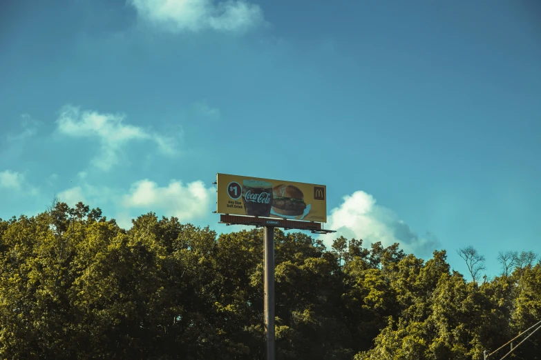 a billboard sign is near a bunch of trees