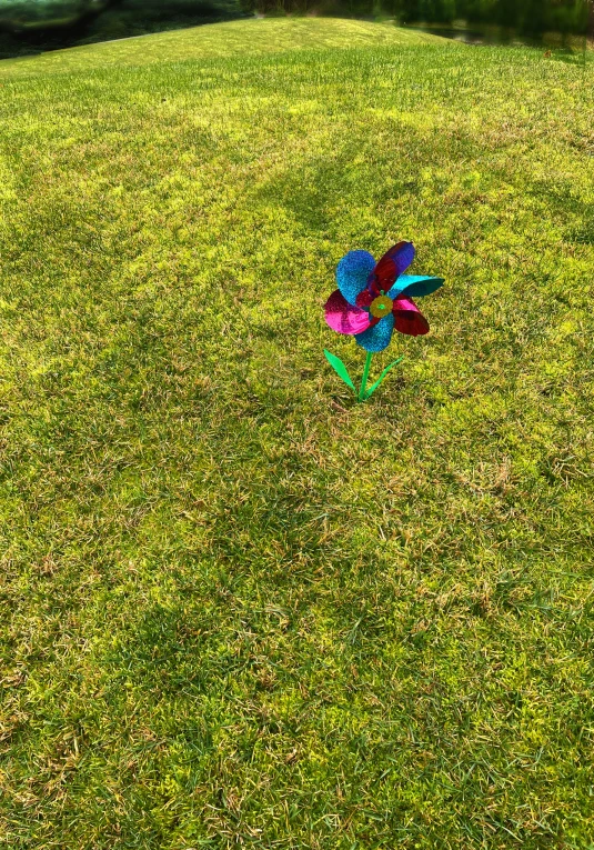 a sculpture of multicolored flowers on the grass