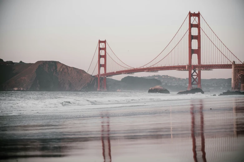 a body of water and a bridge with reflection in the water