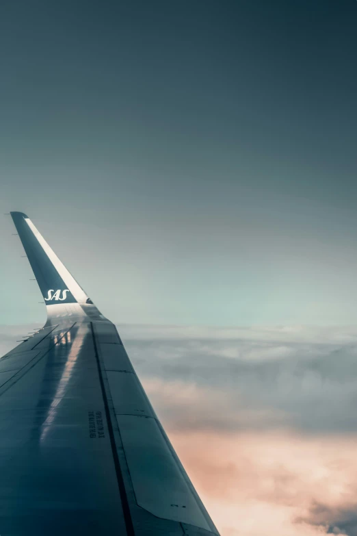 the wing of an airplane flying above clouds