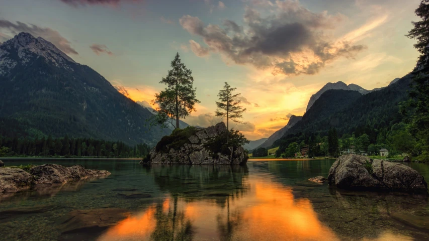 an island in the middle of a lake in front of some mountains