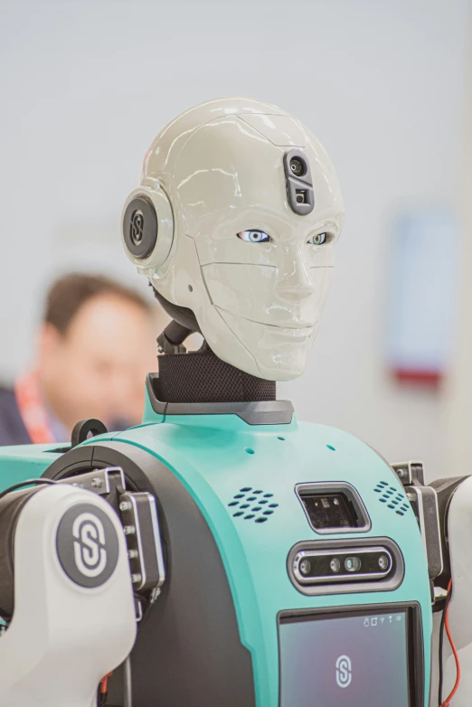 a robot sitting on top of a table next to a white and black head