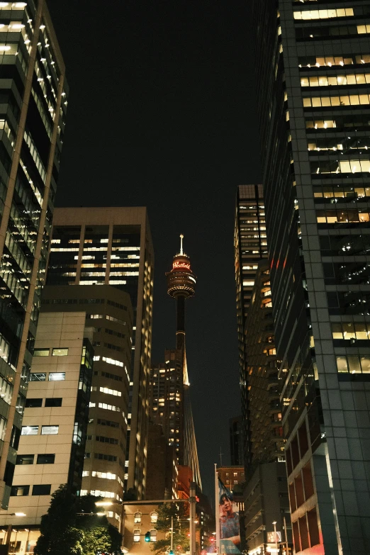 tall buildings lit up at night with a clock tower