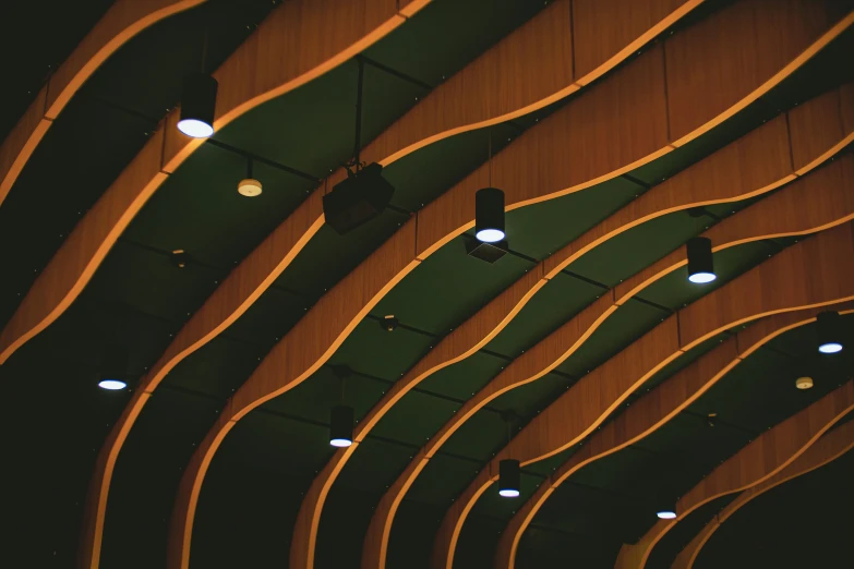 an auditorium is filled with wooden benches and lights