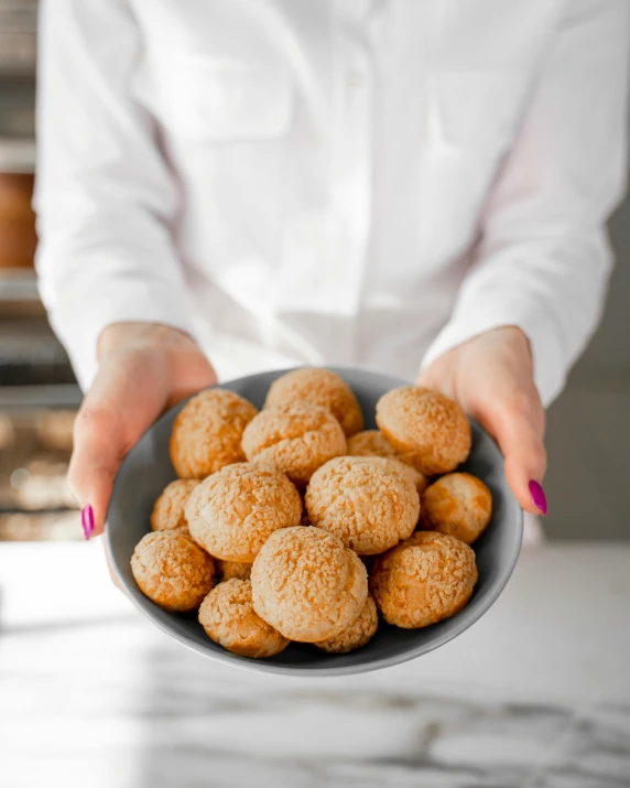 a person holding a bowl of food on a counter